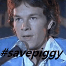 a man is singing into a microphone with the hashtag #savepiggy written below him