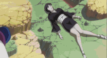 a woman in a black dress is laying on the ground in a desert .