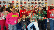 a group of people wearing ugly christmas sweaters pose for a picture