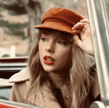 a woman wearing a brown hat is sitting in a car .