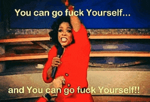 oprah winfrey is standing on a stage holding a microphone and screaming .