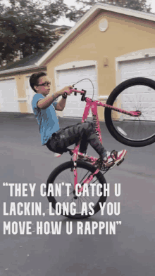 a young boy is doing a trick on a pink bike with a quote behind him