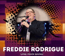 a man singing into a microphone with the name freddie rodriguez one man band