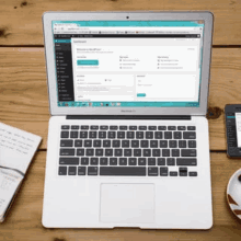 a laptop is open to a dashboard page on a wooden desk