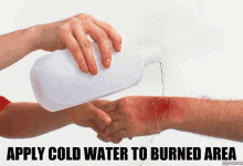 a person is pouring cold water on a burned area on another person 's arm .