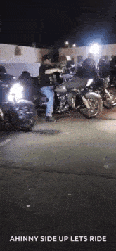 a man is standing on a motorcycle in front of a crowd of motorcycles .