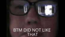 a close up of a person wearing glasses with the words btm did not like that below them