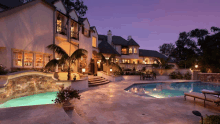 a large house with a swimming pool in front of it at night