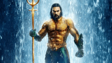 a man in a golden suit is holding a trident in the water