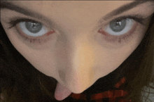 a close up of a woman 's eyes with her tongue out