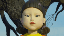 a close up of a doll with a yellow shirt on