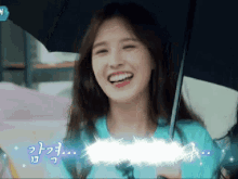 a girl is smiling while holding an umbrella with korean writing on the bottom