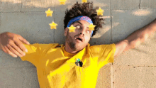 a man wearing a yellow shirt and a headband with stars on his face