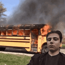 a man is standing in front of a burning school bus