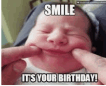 a baby is making a funny face while being held by a person and says `` smile it 's your birthday '' .