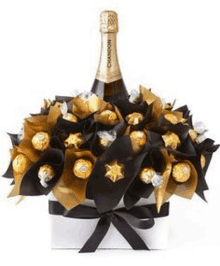 a bottle of champagne is sitting on top of a box filled with chocolates .