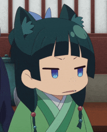 a girl with black hair and blue eyes is wearing a green robe