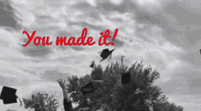 a black and white photo of graduates throwing their caps in the air with the words " you made it " above them