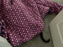 a blanket with a pattern of squares is laying on the floor