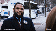 a man in a suit and tie is standing in front of a bus that says best on the back