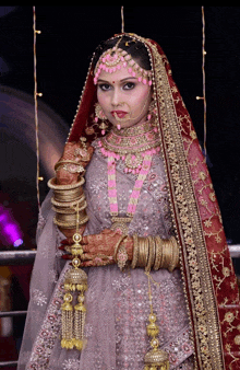 a woman in a bride 's dress is wearing many bracelets