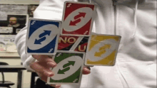 a person holding four uno cards in their hands