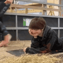 a boy laying on a mat with a sign in the background that says ' more stable & healthy animals '