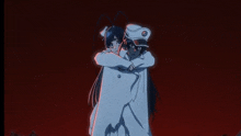 two anime characters are hugging each other in a dark room .