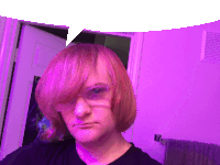 a man with pink hair and glasses looks at the camera