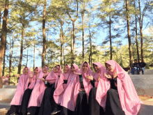 a group of women wearing pink hijabs are posing for a photo