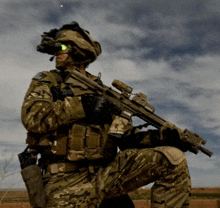 a soldier is kneeling down with a rifle in his hand