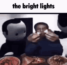 a man is sitting at a table with a bunch of food and the words the bright lights above him