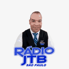 a man wearing a vest and tie stands in front of a radio jtb logo