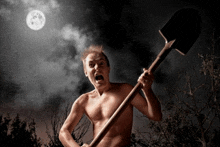 a man without a shirt is holding a shovel in the dark