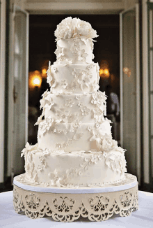 a white cake with flowers on it is on a table