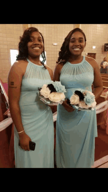 two bridesmaids in light blue dresses holding bouquets