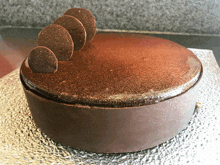 a chocolate cake is sitting on a glass plate