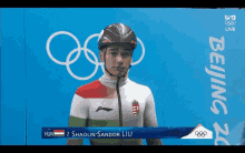 a man wearing a helmet stands in front of a sign that says beijing 20