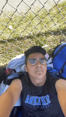 a man wearing sunglasses and a shirt that says ameyar takes a selfie