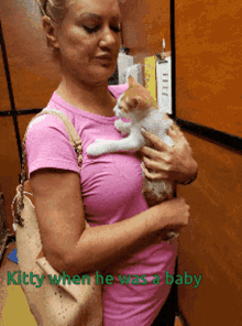 a woman in a pink shirt is holding a kitten with the words kitty when he was a baby below it