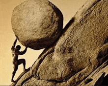 a statue of a man pushing a large rock up a hill .