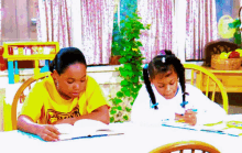 two girls sit at a table with one wearing a yellow shirt that says ' i love you ' on it