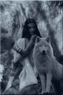 a black and white photo of a woman sitting next to a wolf with the name vica on the bottom