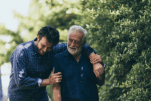 a man is helping an older man walk