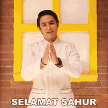 a man in a white shirt is standing in front of a yellow door and says selamat sahur on the bottom