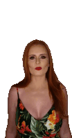 a woman with long red hair is wearing a floral tank top