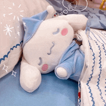 a stuffed animal is laying on a bed next to a pillow