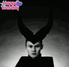 a black and white photo of a man with horns and the words happy tuesday on the bottom