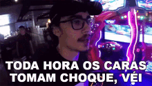 a man wearing glasses and a hat says toda hora os caras tomam choque