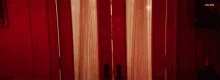 a woman is standing in a room with red walls and a red door .